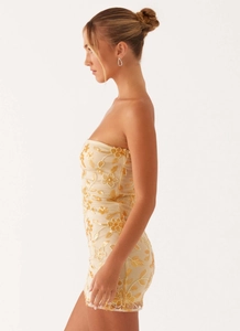 Detailed view of champagne floral embroidery and delicate sequins on strapless dress