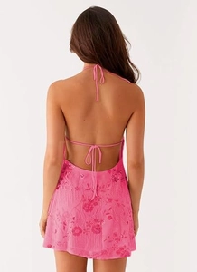 Vue détaillée du dos d'une mini robe Y2K rose avec des paillettes et broderies florales