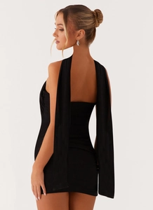 Détail de la robe bustier noire moulante avec de longs rubans décoratifs en tissu à l'épaule