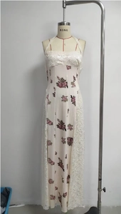 Detail of floral print maxi dress with delicate white lace patchwork and halter neck