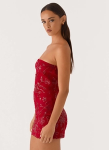 Detailed view of red sequin floral embroidery and beads on a strapless bodycon dress