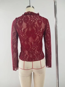 Detail of burgundy floral lace fabric and scalloped edge on long sleeve crop top