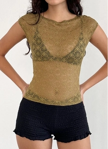 Detalle de la textura de encaje floral verde oscuro en un top transparente de estilo Y2K