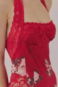 Close-up of red floral lace neckline and vintage printed satin bodice on a slim dress
