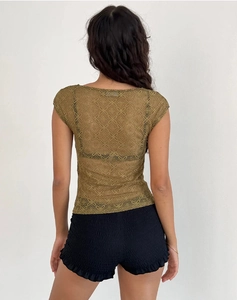 Vista trasera del top de encaje floral verde oliva con pantalones cortos negros rizados