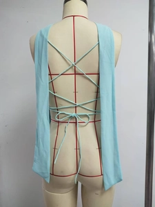 Detail of light blue backless top with criss-cross strappy ties and bow design