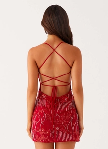 Detailed view of red sequin backless evening dress with elegant crisscross strappy design