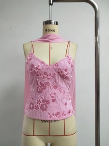 Detail of pink sequin vest top with floral embroidery and thin straps on a mannequin
