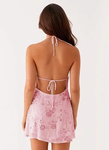 Détail de robe rose Y2K à paillettes avec dos nu et motifs floraux brodés de perles