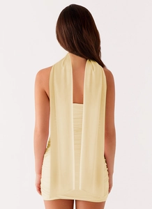 Détail du dos nu de la mini robe froncée avec longs liens de cou flottants en crème