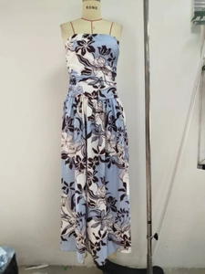 Détail d'une robe longue fleurie avec fines bretelles et taille haute plissée élégante