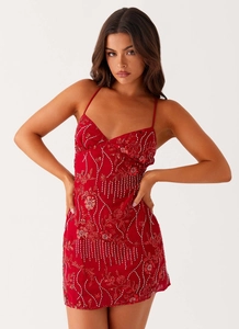 Detail of red sleeveless mini dress featuring intricate sequin embroidery and beadwork