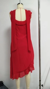 Detail of red chiffon dress featuring ruffle hem and elegant back ribbon ties