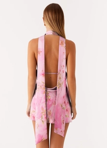 Detail of pink floral halter dress featuring an open back and long satin ribbons