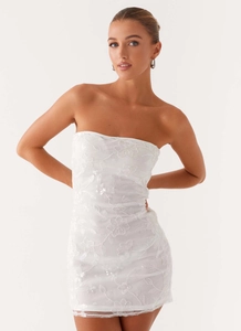 Close-up of white tube mini dress featuring floral embroidery and shimmering sequins detail
