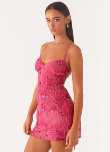 Detail view of a pink beaded mini dress with floral sequins and spaghetti straps.