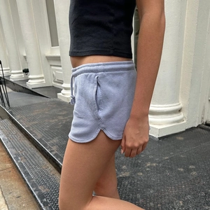 Detailansicht der hellgrauen Waffelstrick-Shorts mit Gummibund und seitlichem Schlitz