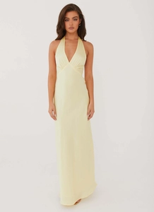 Elegant pale yellow halter neck maxi dress with deep V-neck in satin finish fabric