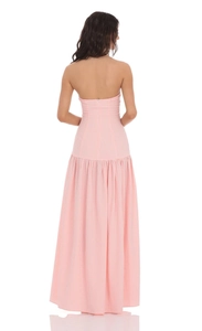 Vista trasera de un vestido largo de cuadros rosa con cremallera oculta y dobladillo plisado