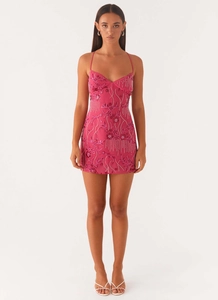 Close-up of intricate sequin floral embroidery and beaded texture on pink mini dress