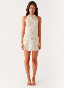 Détail de mini robe licou Y2K blanche avec broderies florales dorées et paillettes