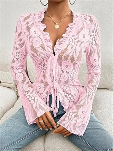Detail of pink lace cardigan featuring floral embroidery and ruffle trim with tie front