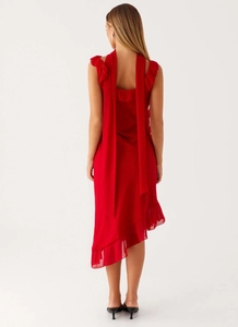 Detail of red chiffon midi dress with back ribbons and ruffled asymmetric hemline