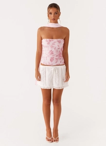Pink sequin floral tube top paired with white eyelet lace skirt and silk scarf detail