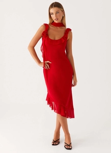 Detail of red chiffon dress featuring 3D floral accent and irregular ruffled hemline
