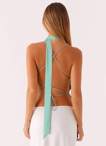 Close-up of mint green backless sequin top with criss-cross straps and elegant long neck sash