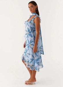 Detailed close-up showing the blue floral print and ruffled chiffon texture of the dress