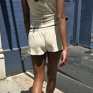 Detail der hellbeigen Strickshorts mit elastischem Kordelzug und gewelltem Saum