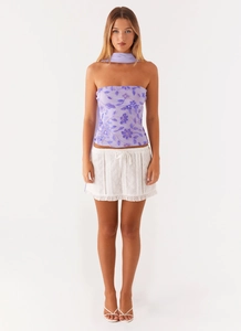 Detail of purple sequin flower embroidery on backless mesh tube top with white lace skirt