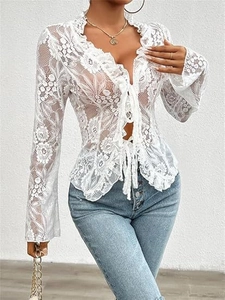 Detail view of women's white floral lace top with front ties and ruffle V-neckline