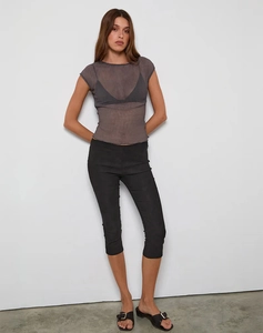 Top de malla transparente con pantalones cortos ajustados negros y sandalias de hebilla