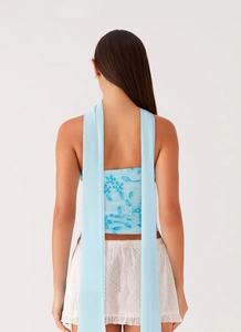 Detail of light blue sequined floral embroidery and elegant long back ribbons on summer dress