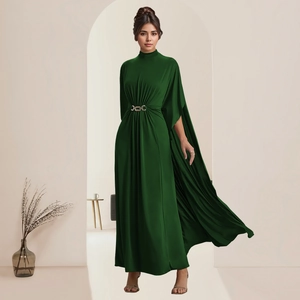 Detail eines waldgrünen Satin-Abendkleids mit goldener Gürtelschnalle und Umhangärmel