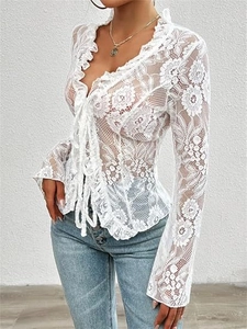 Detailed view of floral lace pattern and ruffle trim on white sheer tie-front top