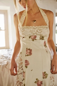 Detail of floral lace patchwork and pink rose print on halter-neck dress with heart necklace