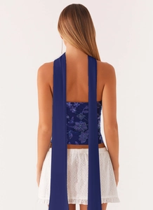 Detail of dark blue sequin flower embroidery on backless halter top with long straps