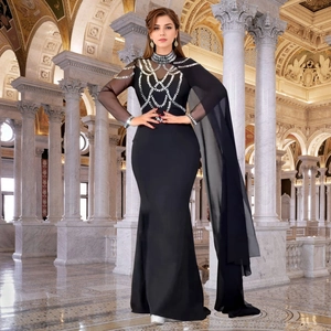Détail de la robe de soirée noire avec strass argentés et cape en maille transparente