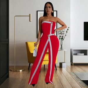 Detail of red tube top jumpsuit featuring white piping and golden lion head buttons