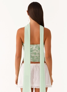 Detail of sequined floral embroidery on the backless top paired with white eyelet skirt