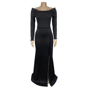 Detail of elegant black long sleeve evening gown with sparkling rhinestone edge split