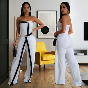 Detailed view of white strapless jumpsuit featuring black trim and gold buttons