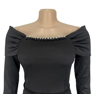 Detail of off-shoulder neckline with black and white beads on an elegant evening dress