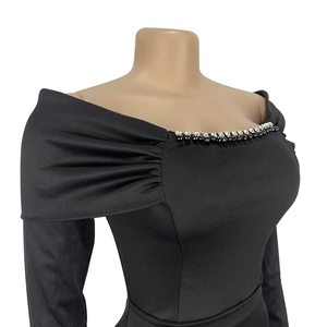 Close-up of elegant black dress with beaded neckline and pleated bodice detail