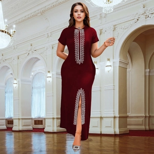 Détail de robe fourreau bordeaux élégante avec strass argentés et fente sur le devant
