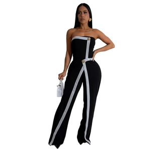 Detail view of strapless black jumpsuit featuring white side stripes and gold button accents