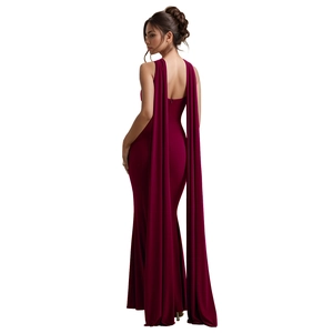 Detail of burgundy backless velvet gown with flowing cape and elegant fishtail hem